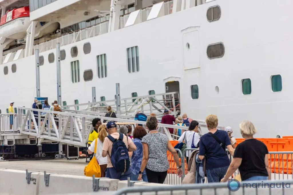 cola de pasajeros con maletas esperando para embarcar en una terminal de cruceros en verano