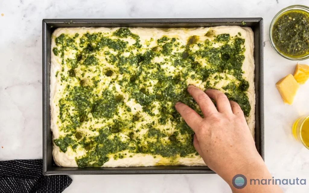 focaccia genovesa y pasta con pesto servidas en una mesa