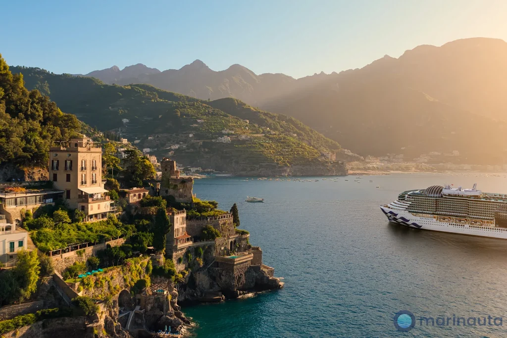 pueblo costero del Mediterráneo con luz de septiembre y un crucero fondeado al fondo