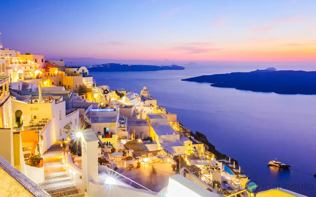 la caldera de Santorini con un crucero fondeado y las casas blancas en lo alto del acantilado