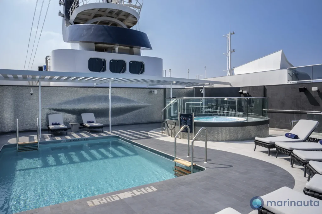 terraza con tumbonas y piscina en la zona exclusiva de un crucero