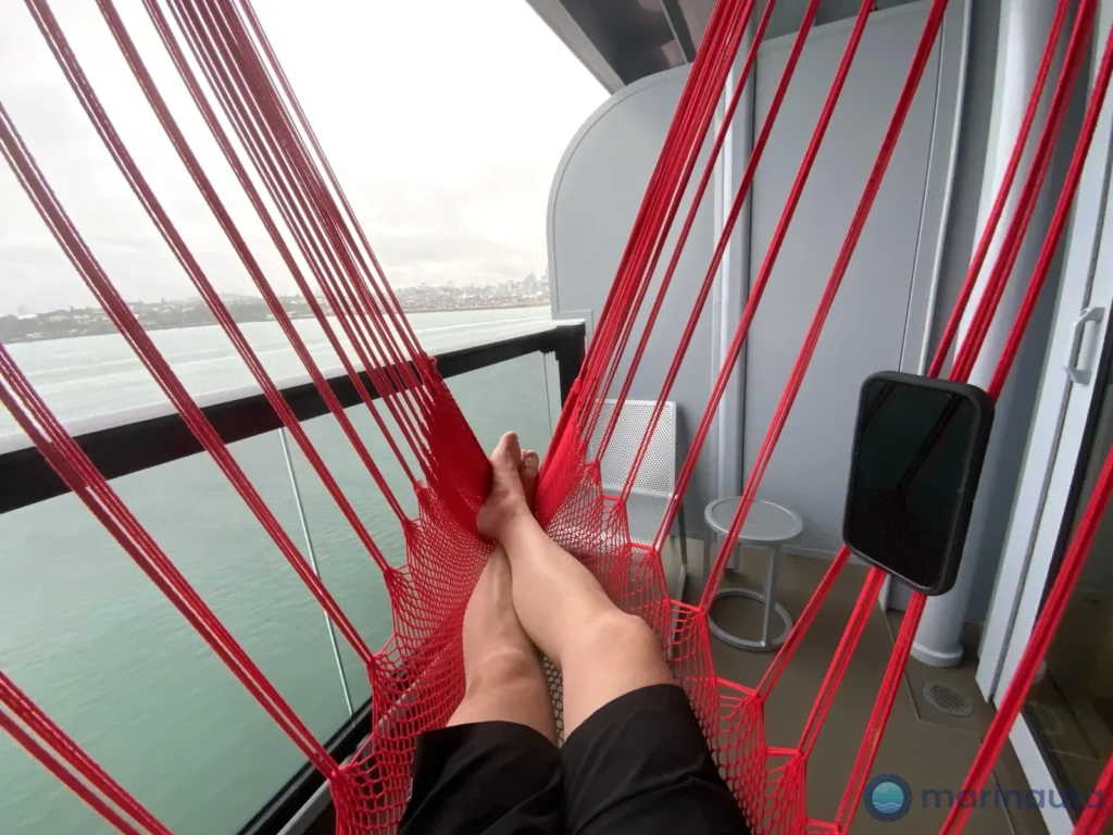camarote moderno de crucero con terraza, hamaca y vista al mar